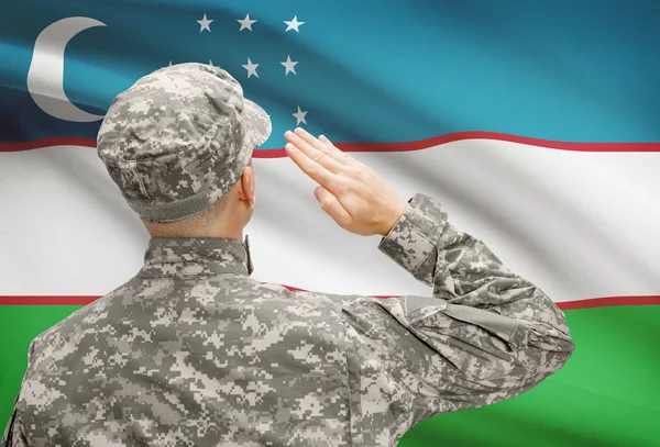 Soldaat in hoed geconfronteerd met nationale vlag serie - Oezbekistan — Stockfoto