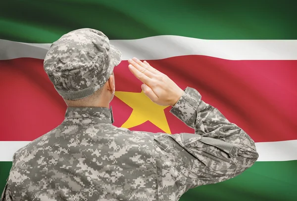 Солдат в шляпе, стоящие перед национальным флагом серии - Суринам — стоковое фото