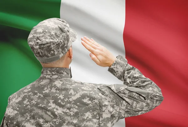 Солдат в шляпе, стоящие перед национальным флагом серии - Италия Стоковое Изображение
