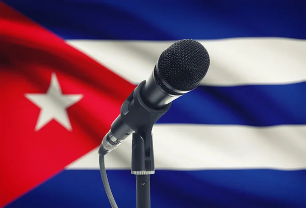 Micrófono en pedestal con bandera nacional de fondo - Cuba —  Fotos de Stock