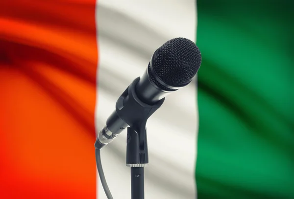 Microphone sur pied avec un drapeau national sur fond - Côte d'Ivoire — Photo