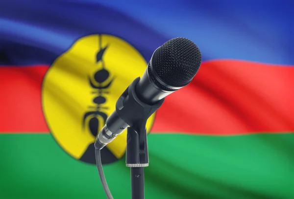 Micrófono en pedestal con bandera nacional de fondo - Nueva Caledonia —  Fotos de Stock