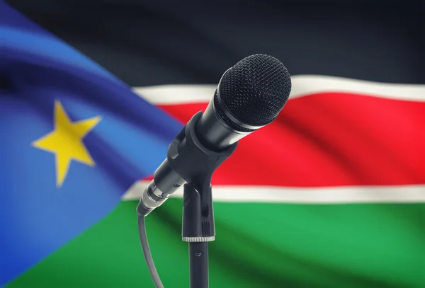 Микрофон на подставке с национальным флагом на фоне - Южный Судан — стоковое фото