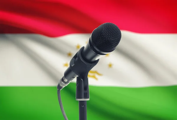 Microphone sur pied avec un drapeau national sur fond - Tadjikistan — Photo