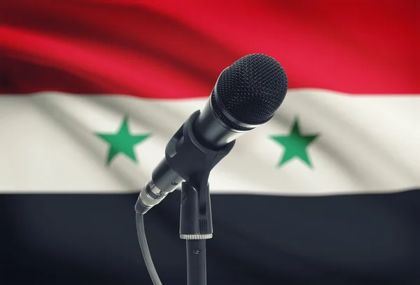 Microphone sur pied avec un drapeau national sur fond - Syrie — Photo