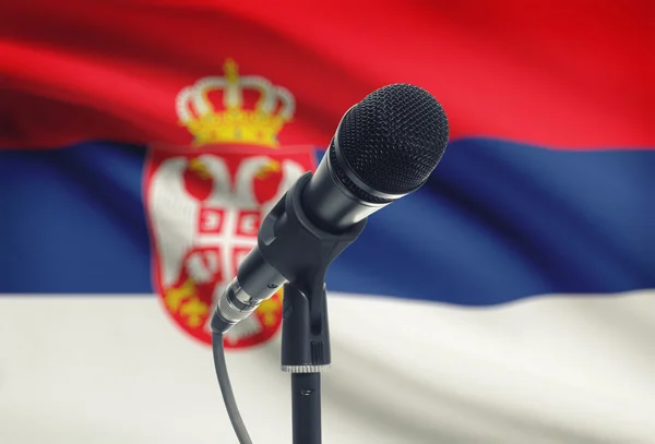 Микрофон на подставке с национальным флагом на фоне - Сербия — стоковое фото