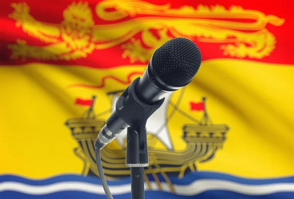 麦克风在立场上与加拿大省国旗背景-新不伦瑞克省 — 图库照片