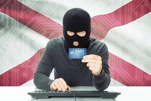 Hacker drží kreditních karet a Usa státní vlajky na pozadí - Alabama — Stock fotografie