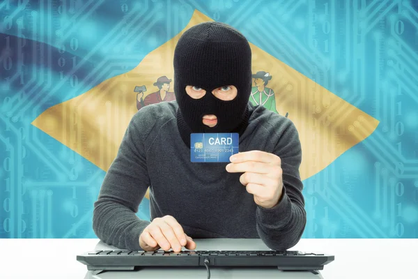 Хакер, проведения кредитной карты и флага США на фоне - Делавэр — стоковое фото