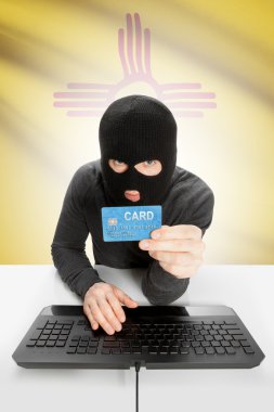 Hacker holding credit card with US state flag on background - New Mexico