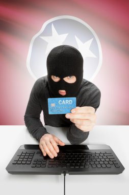 Hacker holding credit card with US state flag on background - Tennessee
