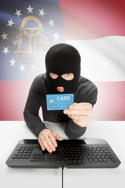 Hacker holding credit card with US state flag on background - Georgia — Stock Photo, Image