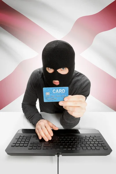 Hacker holding credit card with US state flag on background - Alabama — Stok fotoğraf