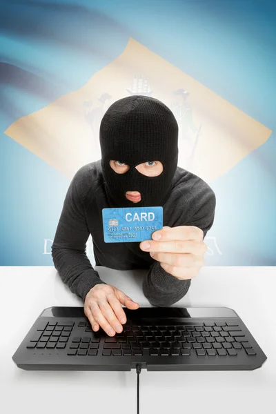 Hacker holding credit card with US state flag on background - Delaware —  Fotos de Stock