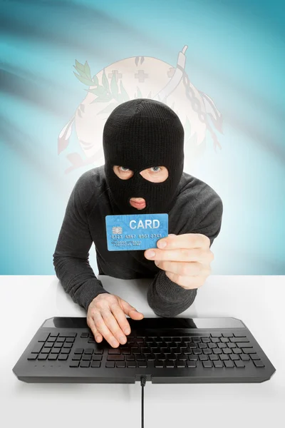 Hacker holding credit card with US state flag on background - Oklahoma — Foto Stock