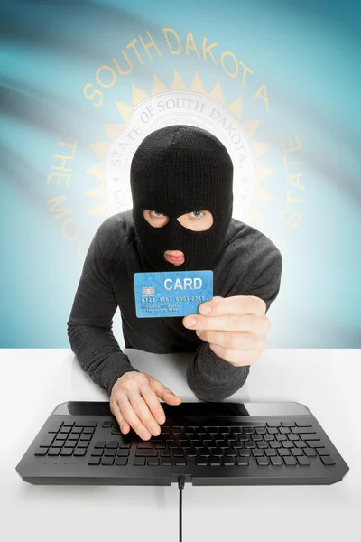 Hacker holding credit card with US state flag on background - South Dakota — Stock Photo, Image