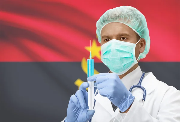 Médecin avec une seringue dans les mains et le drapeau sur la série de fond - Angola — Photo