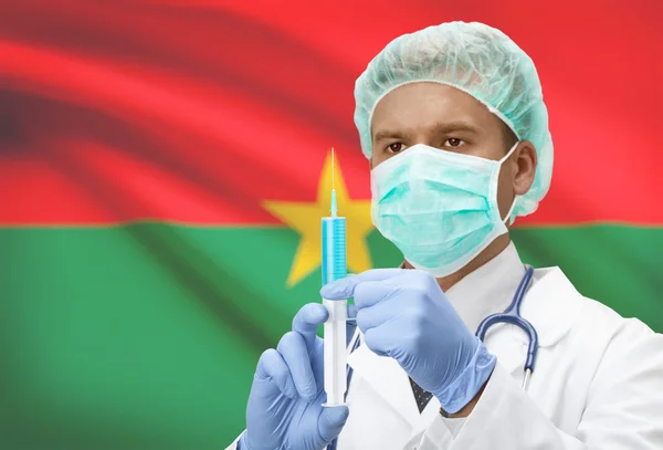 Médico con jeringa en las manos y la bandera en la serie de fondo - Burkina Faso —  Fotos de Stock