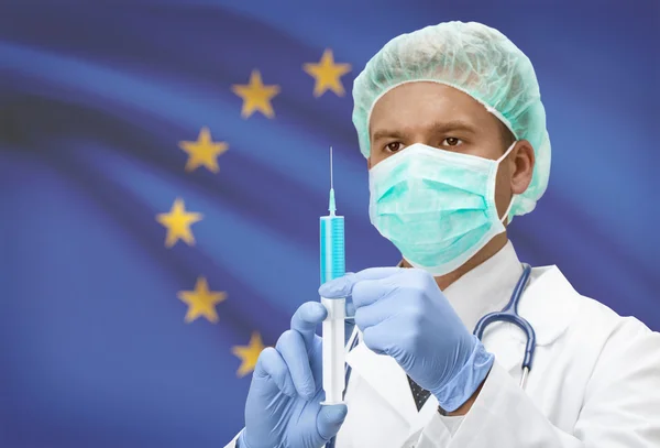 Médico con jeringa en las manos y la bandera en la serie de antecedentes - Unión Europea - UE — Foto de Stock