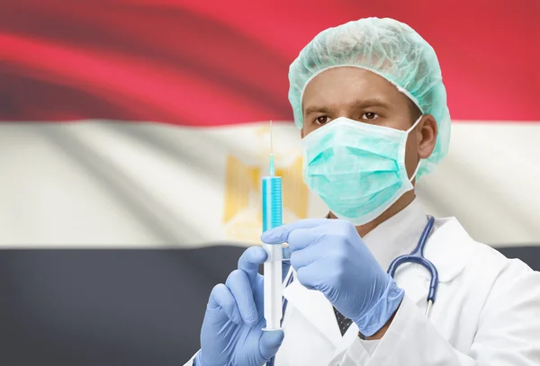 Médecin avec une seringue dans les mains et le drapeau sur la série de fond - Egypte — Photo