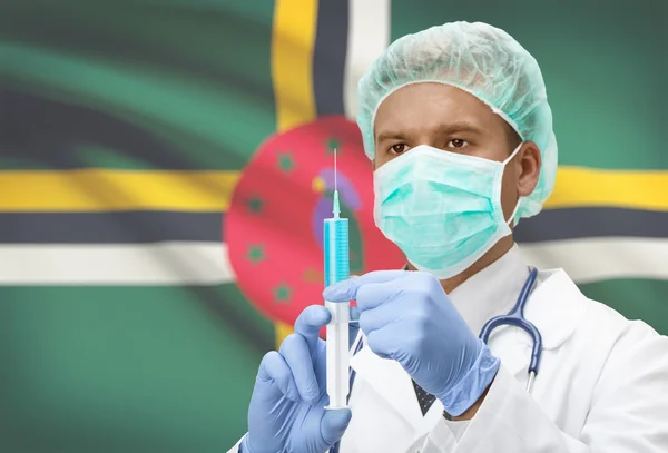 Médico con jeringa en las manos y la bandera en la serie de fondo - Dominica — Foto de Stock