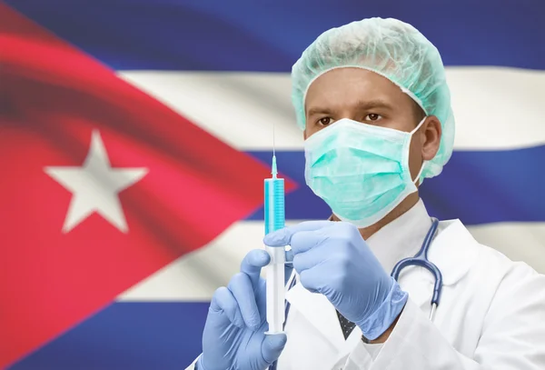 Médico com uma seringa nas mãos e bandeira na série de fundo - Cuba — Fotografia de Stock