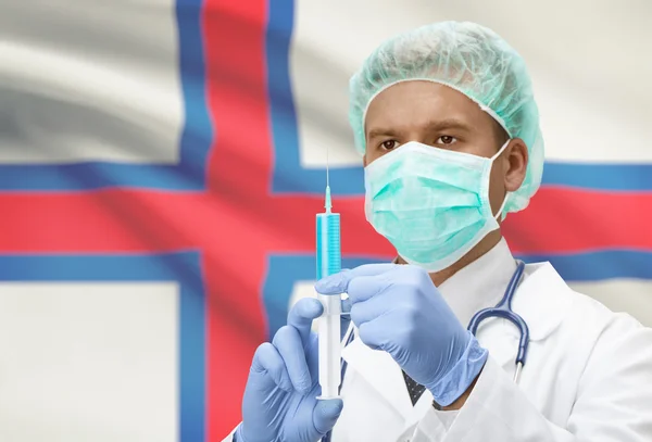 Médico con jeringa en las manos y la bandera en la serie de fondo - Islas Feroe — Foto de Stock