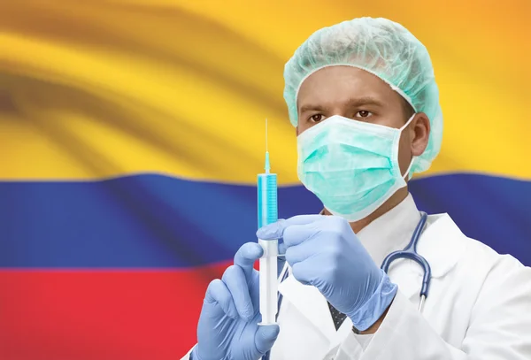 Médecin avec une seringue dans les mains et le drapeau sur la série de fond - Colombie — Photo