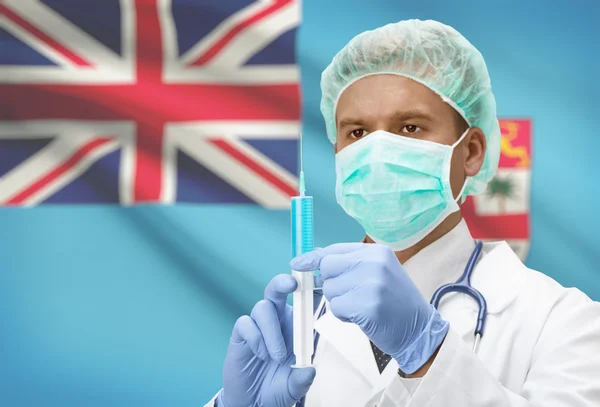 Arzt mit Spritze in Händen und Flagge auf Hintergrund-Serie - Fidschi — Stockfoto