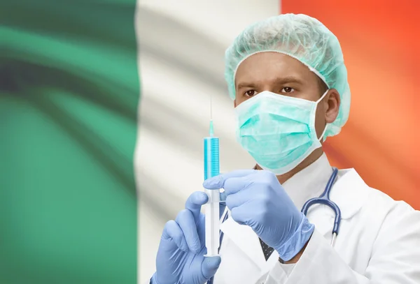 Médecin avec une seringue dans les mains et le drapeau sur la série de fond - Irlande — Photo