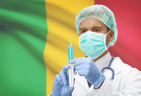 Médico con jeringa en las manos y la bandera en la serie del fondo - Malí — Foto de Stock