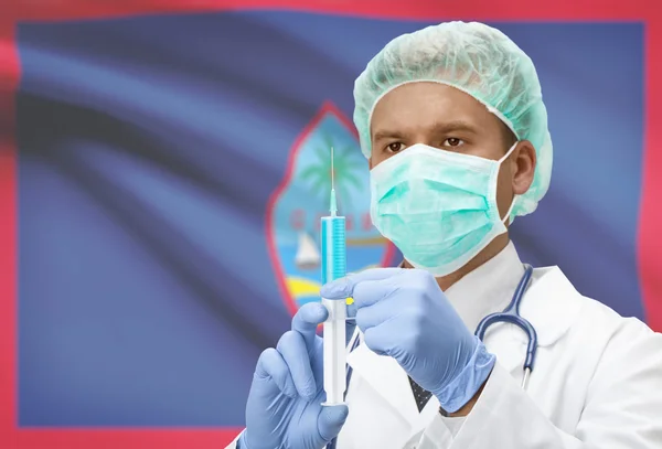 手と背景シリーズ - グアムの旗で注射器を持つ医師 — ストック写真