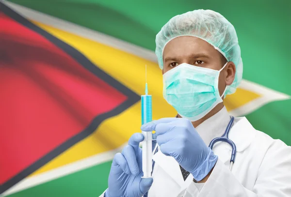 Medico con la siringa nelle mani e bandiera sulla serie della priorità bassa - Guyana — Foto Stock