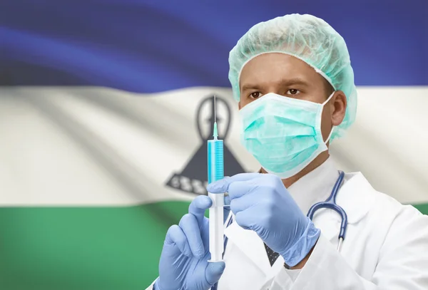 Médico con jeringa en las manos y la bandera en la serie del fondo - Lesotho —  Fotos de Stock