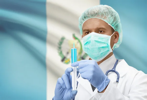 Médecin avec une seringue dans les mains et le drapeau sur la série de fond - Guatemala — Photo