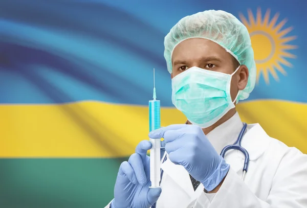 Médecin avec une seringue dans les mains et le drapeau sur la série de fond - Rwanda — Photo