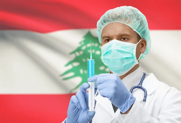 Médico con jeringa en las manos y la bandera en la serie de fondo - Líbano — Foto de Stock