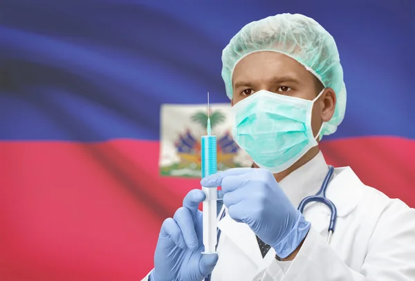 Médico con jeringa en las manos y la bandera en la serie de fondo - Haití — Foto de Stock