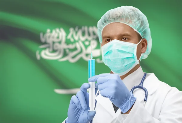 Médecin avec une seringue dans les mains et le drapeau sur la série de fond - Arabie saoudite — Photo