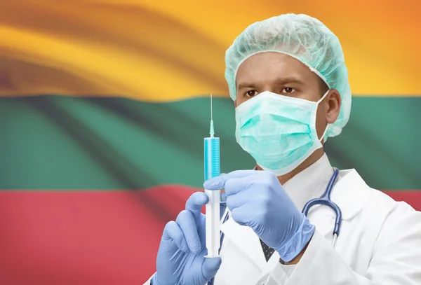 Médecin avec une seringue dans les mains et le drapeau sur la série de fond - Lituanie — Photo