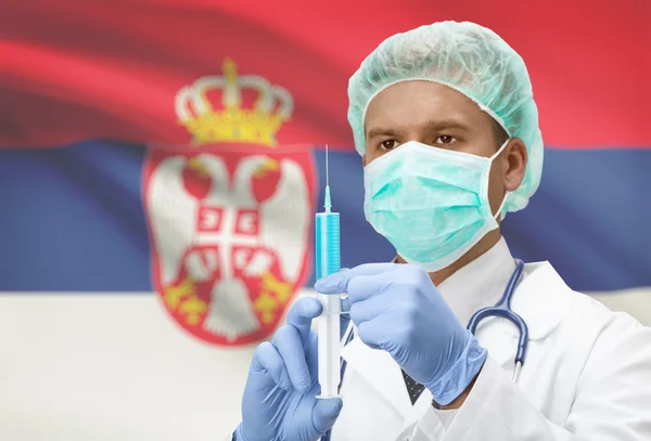 Arzt mit Spritze in Händen und Flagge auf Hintergrund-Serie - Serbien — Stockfoto