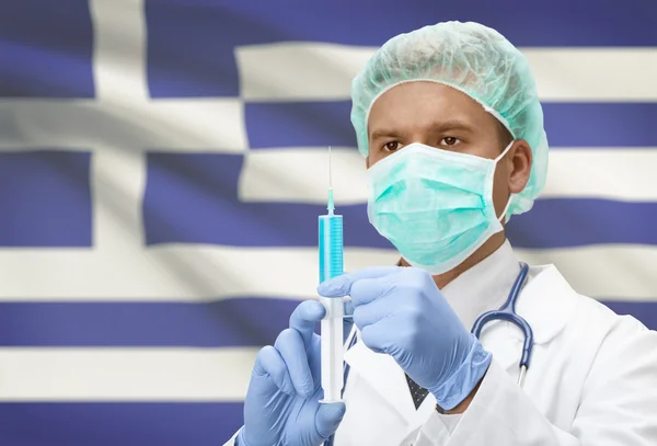 Médecin avec une seringue dans les mains et le drapeau sur la série de fond - Grèce — Photo