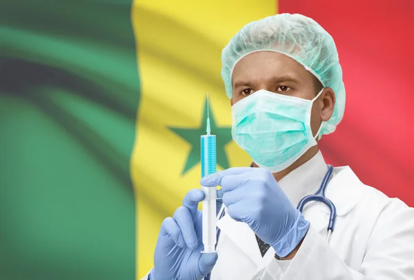 Médico con jeringa en las manos y la bandera en la serie de fondo - Senegal —  Fotos de Stock