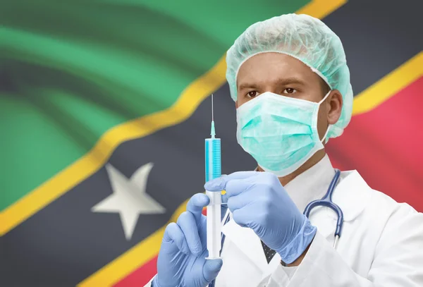 Médecin avec une seringue dans les mains et le drapeau sur la série de fond - Saint-Kitts-et-Nevis — Photo