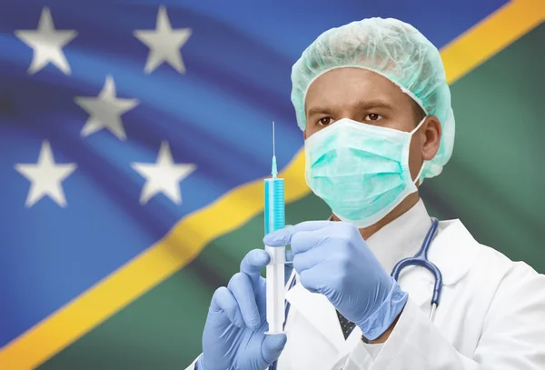 Médico con jeringa en las manos y la bandera en la serie de fondo - Islas Salomón — Foto de Stock