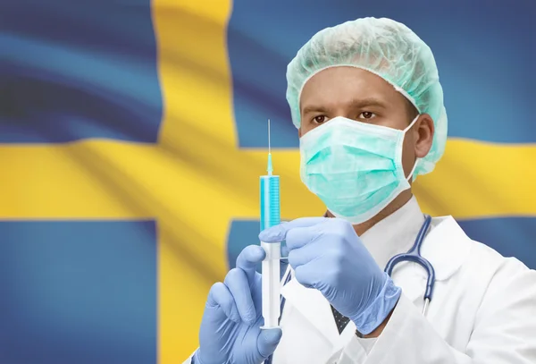 Médecin avec une seringue dans les mains et le drapeau sur la série de fond - Suède — Photo