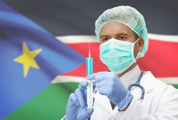 Médecin avec une seringue dans les mains et le drapeau sur la série de fond - Soudan du Sud — Photo