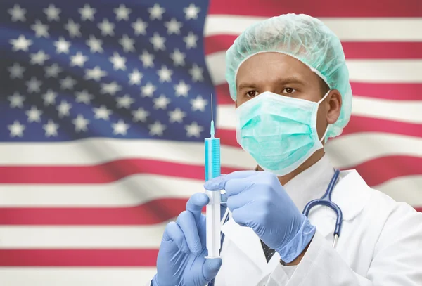 Doctor with syringe in hands and flag on background series - United States — Stock Photo, Image