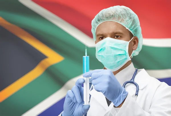 Médico con jeringa en las manos y la bandera en la serie de fondo - Sudáfrica —  Fotos de Stock