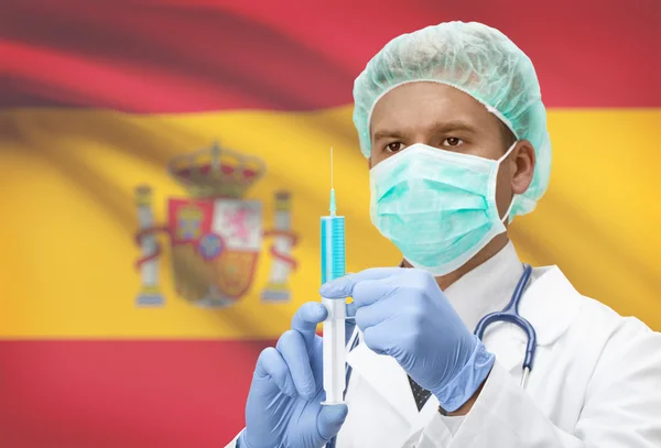 Médico com uma seringa nas mãos e bandeira na série de fundo - Espanha — Fotografia de Stock